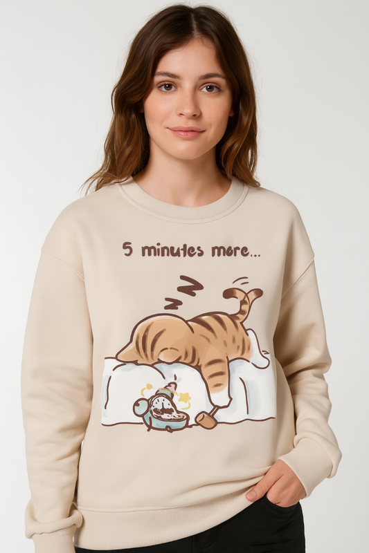 Woman wearing a beige sweatshirt with a cartoon design of a cat and mouse on a white background